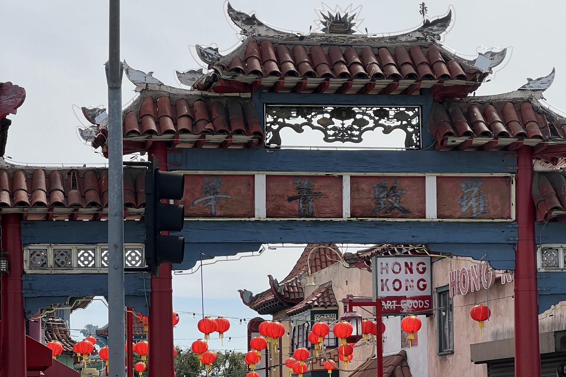 A gate into Chinatown in Los Angeles, with red lanterns strung above the walk beyond it