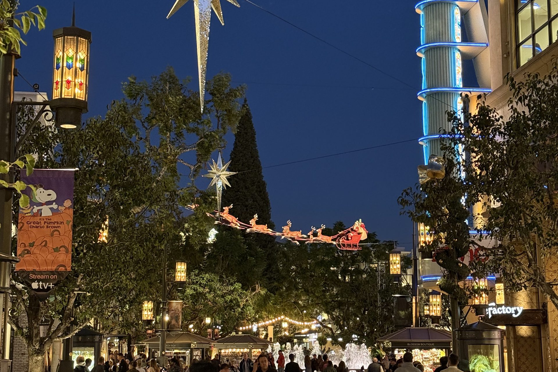 The promenade at The Grove in the evening, busy under holiday decorations