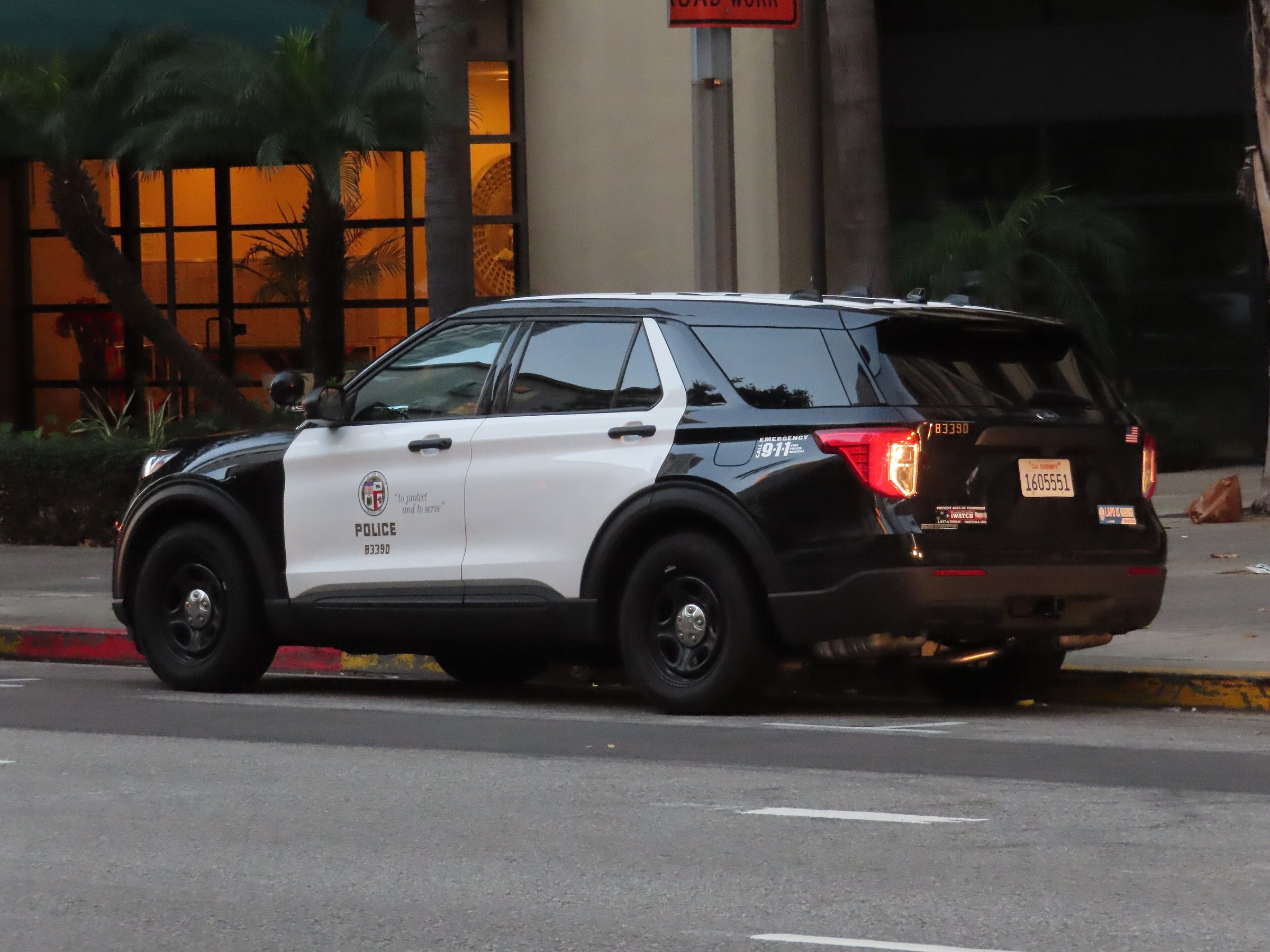 A black-and-white LAPD patrol SUV parked at the curb