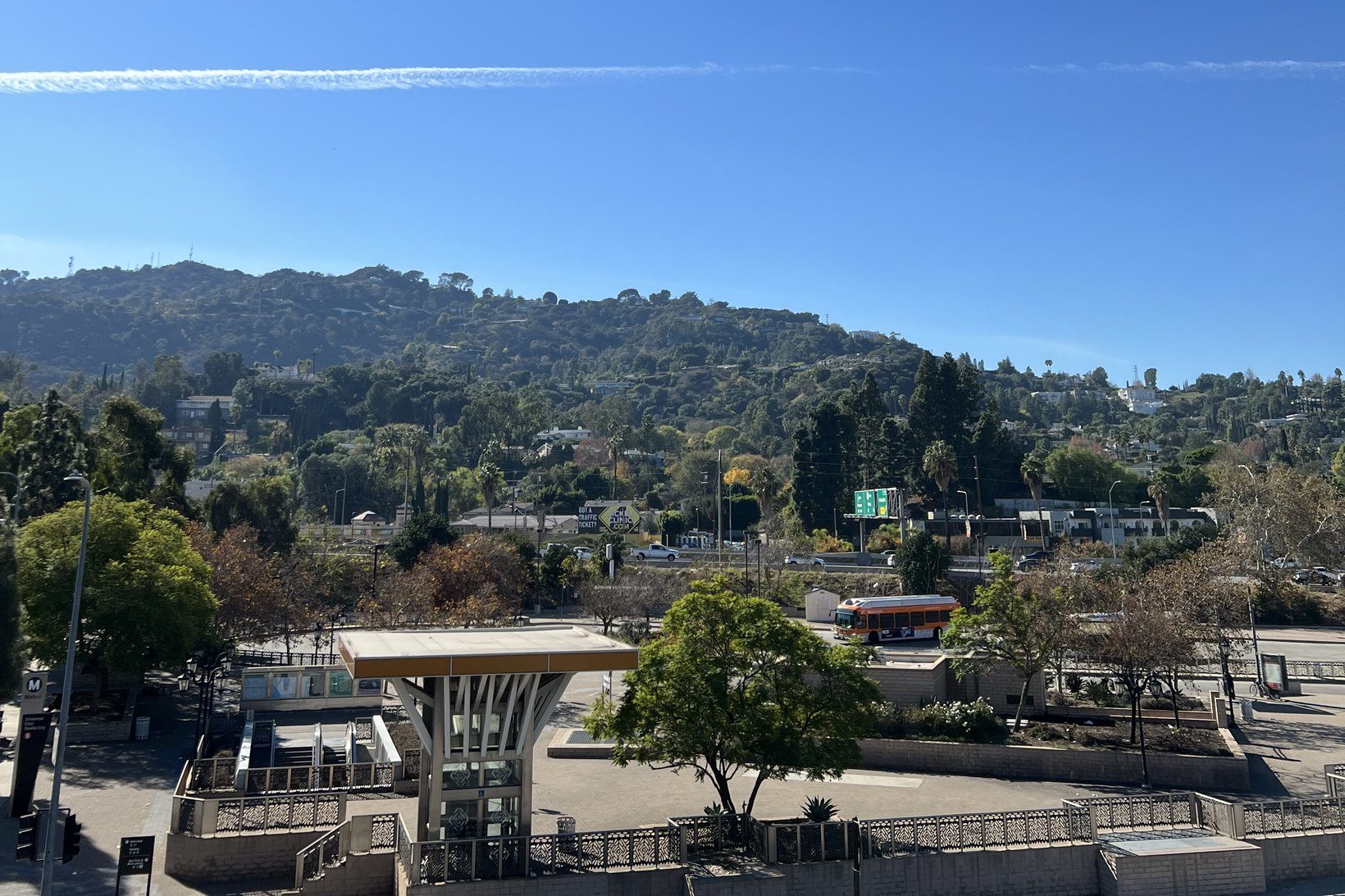 The Metro station at Universal City and Studio City, with Lankershim Boulevard, a Metro bus and the 101 freeway below the wooded hills of the Santa Monica Mountains